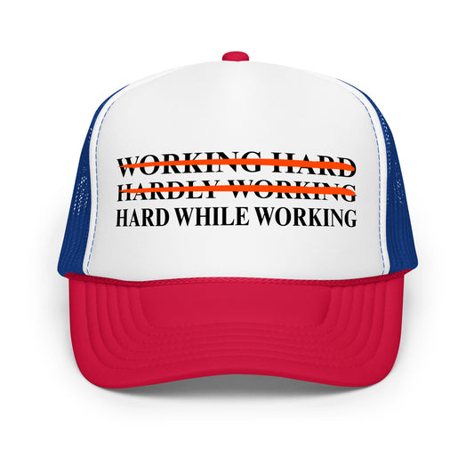 Inappropriate funny mesh trucker hat with bold black text that says “Working Hard Hardly Working Hard While Working” — a hilarious hat for men who love innuendos, dirty humor, and wearing something outrageous to work or parties.